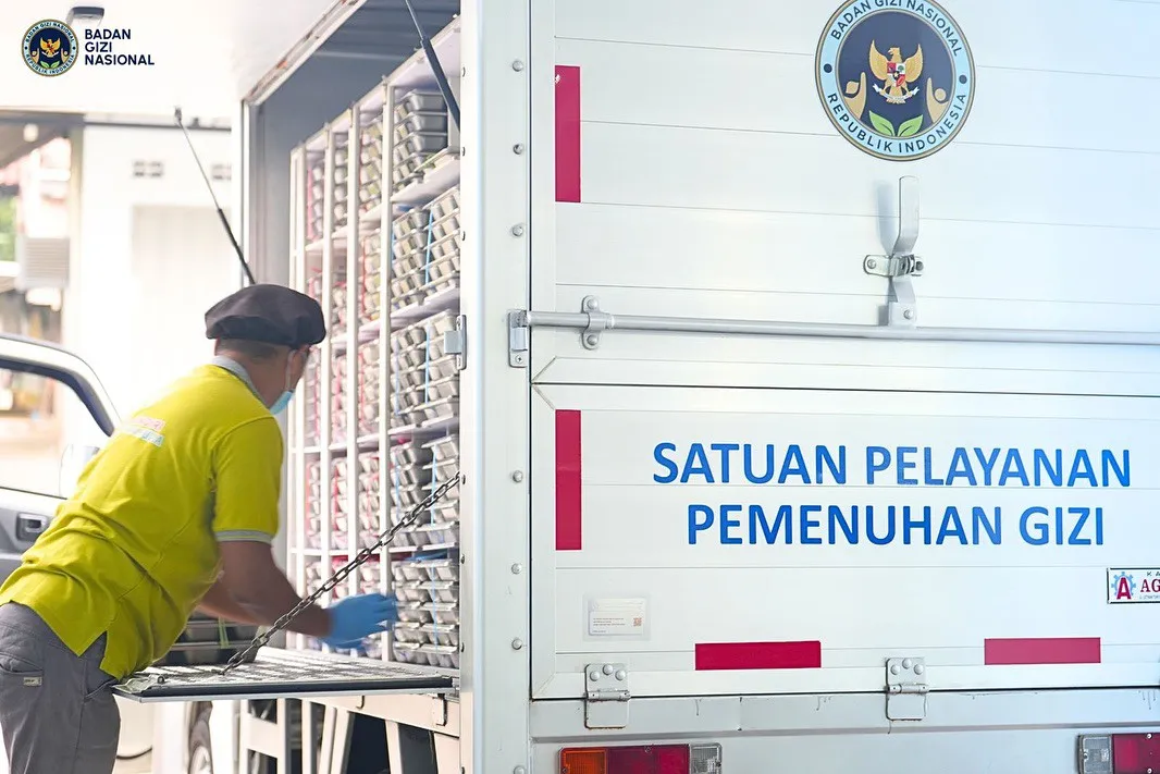Petugas tengah mengatur ompreng MBG yang dimasukkan ke dalam kendaraan operasional SPPG